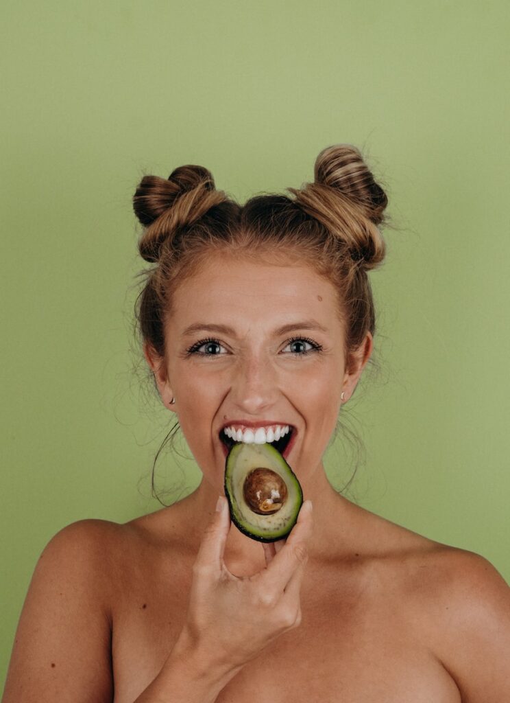 woman holding sliced avocado